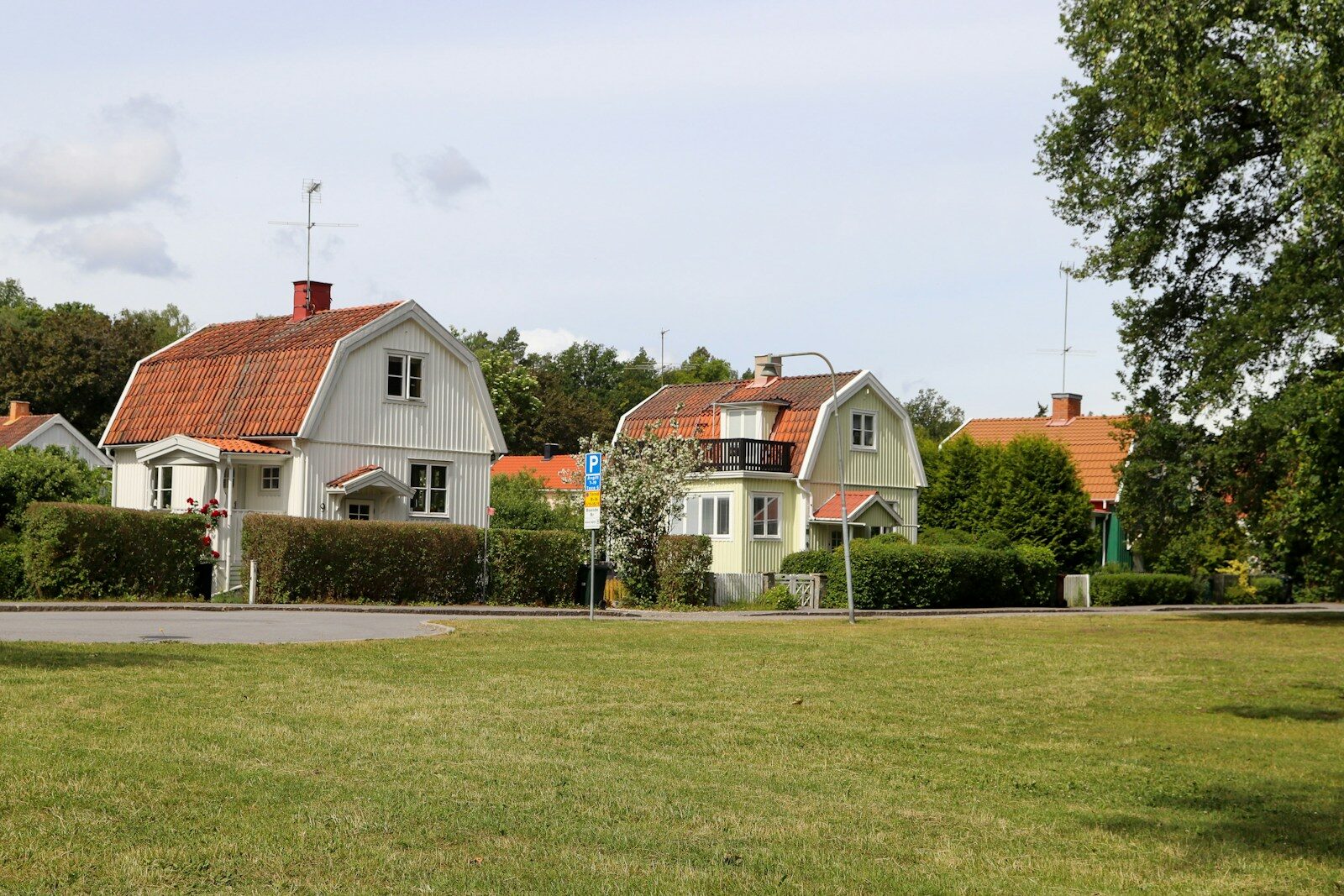 Houses in a suburban neighborhood under a sunny sky.